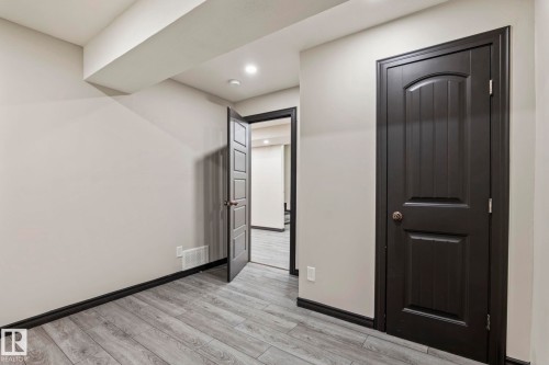Wood-finish flooring, recessed lighting, and dark trim details - 5210 23 Ave Sw, Edmonton, AB - Indoor Photo Showing Other Room