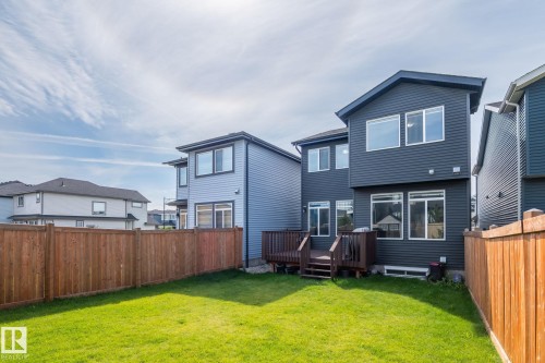 Expansive backyard featuring a manicured lawn, a wooden fence, and a multi-level deck - 5210 23 Ave Sw, Edmonton, AB - Outdoor