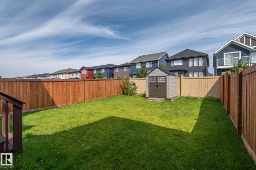 Expansive fenced yard with a manicured lawn and an outdoor storage shed - 5210 23 Ave Sw, Edmonton, AB - Outdoor