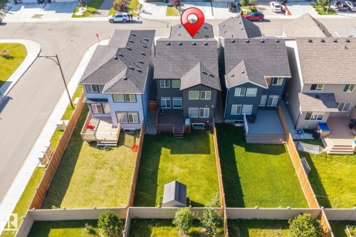 Rear elevation with a wood privacy fence, a wooden deck, and a grass lawn - 5210 23 Ave Sw, Edmonton, AB - Outdoor
