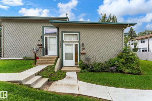 Two separate entrances, each with a white exterior door and an overhead transom window - 6471 180 Street Nw, Edmonton, AB - Outdoor