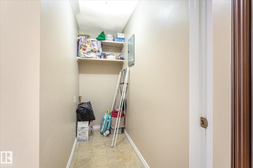 Recessed storage area featuring two built-in shelves and tile flooring - 6471 180 Street Nw, Edmonton, AB - Indoor