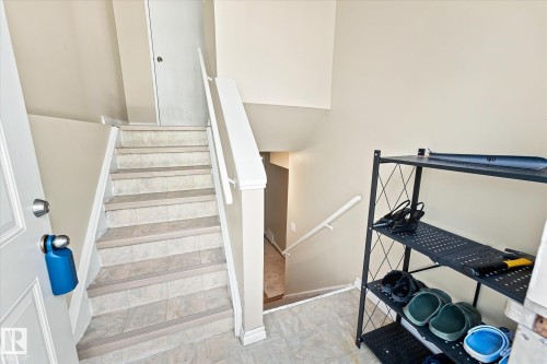 Staircase with tile-finish treads and risers, white painted handrails, and neutral wall tones - 6471 180 Street Nw, Edmonton, AB - Indoor Photo Showing Other Room