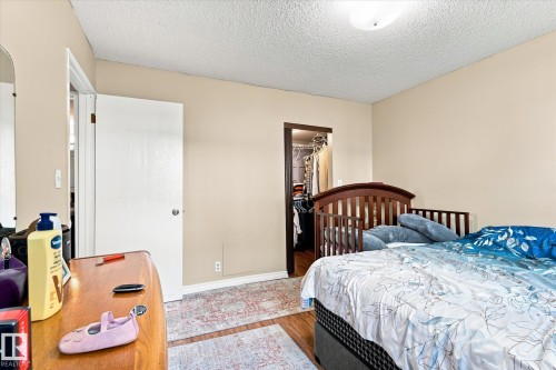 Wood-finish flooring with light beige wall paint - 6471 180 Street Nw, Edmonton, AB - Indoor Photo Showing Bedroom