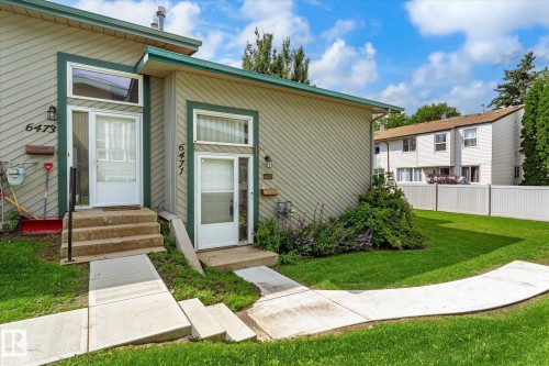 Siding exterior with green trim, individual entrances, and concrete walkways - 6471 180 Street Nw, Edmonton, AB - Outdoor