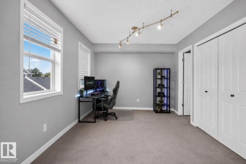 Dual windows with white blinds, track lighting fixture, gray wall paint, and double bi-fold closet doors - 4471 Mccrae Avenue Nw, Edmonton, AB - Indoor