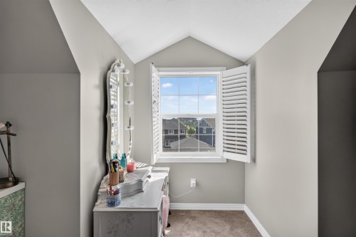 Attic space with sloped walls, a single window with white plantation shutters, and light gray wall paint - 4471 Mccrae Avenue Nw, Edmonton, AB - Indoor