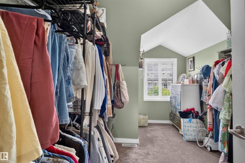 Attic space with sloped ceilings, white-framed window with louvered shutters, and light green painted walls - 4471 Mccrae Avenue Nw, Edmonton, AB - Indoor With Storage