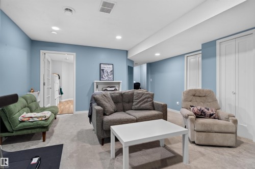 Carpeted flooring, recessed lighting, white interior doors, and a built-in shelving unit - 4471 Mccrae Avenue Nw, Edmonton, AB - Indoor Photo Showing Living Room