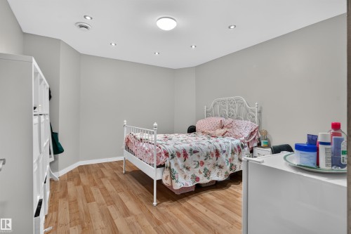 Recessed lighting, central ceiling fixture, wood-finish flooring, light gray wall finish, white trim - 4471 Mccrae Avenue Nw, Edmonton, AB - Indoor Photo Showing Bedroom