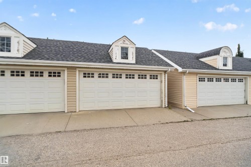 Multiple garage doors with upper window panels - 4471 Mccrae Avenue Nw, Edmonton, AB - Outdoor With Exterior