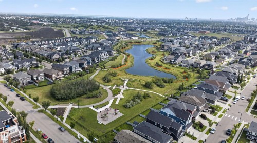 Established residential community with a central water feature, adjacent green spaces, and a visible playground - 4471 Mccrae Avenue Nw, Edmonton, AB - Outdoor With View