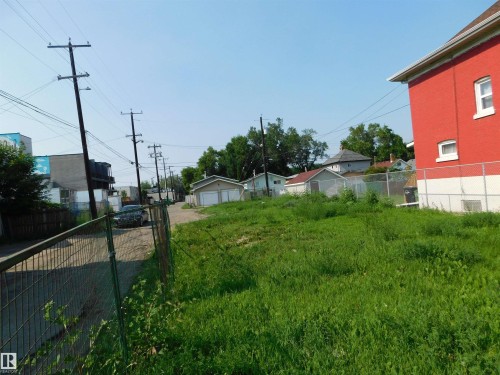 Expansive grass lot bordered by chain link fencing - 9352 107A Avenue Nw, Edmonton, AB 
