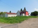 Expansive land parcel featuring a detached shed with a red shingle roof, chain-link perimeter fencing, and established ground cover - 9352 107A Avenue Nw, Edmonton, AB 