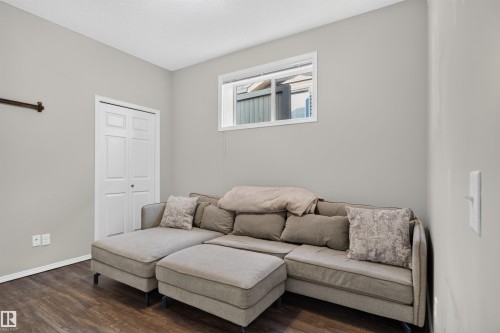 Wood-finish flooring, white trim, and a window with white casing - #34 6520 2 Av Sw, Edmonton, AB - Indoor Photo Showing Other Room
