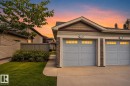 Attached two-car garage with stone accents, horizontal siding, and a gabled roofline - #34 6520 2 Av Sw, Edmonton, AB  - Outdoor 