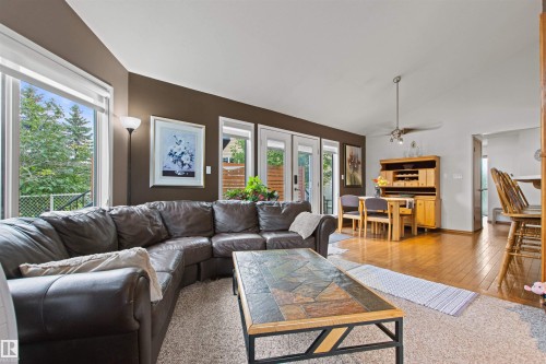 Recessed lighting, wood-finish flooring, and multiple glass panel doors providing outdoor access - 11139 157 Avenue Nw, Edmonton, AB - Indoor Photo Showing Living Room