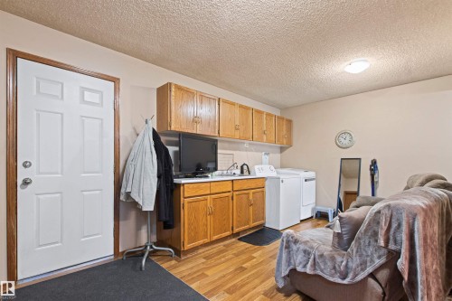 Wood-finish flooring with light-toned walls - 11139 157 Avenue Nw, Edmonton, AB - Indoor Photo Showing Laundry Room