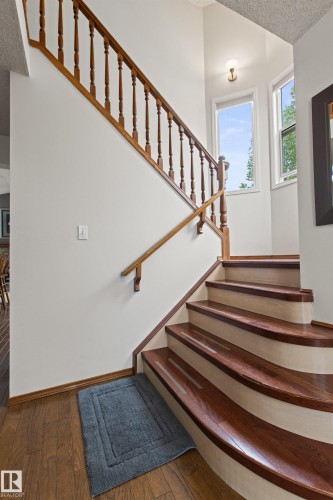 Curved staircase with wood-finish treads and white risers - 11139 157 Avenue Nw, Edmonton, AB - Indoor Photo Showing Other Room