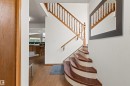 Hardwood flooring throughout, a curved hardwood staircase with white risers, and a wood spindle railing - 11139 157 Avenue Nw, Edmonton, AB  - Indoor Photo Showing Other Room 