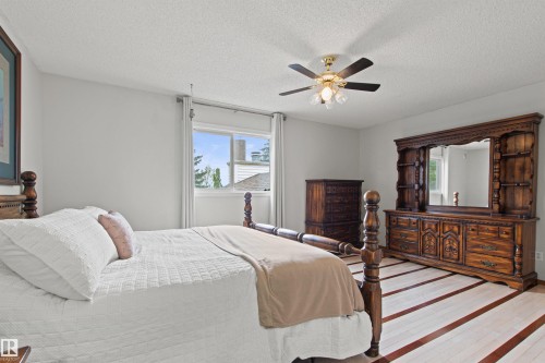 Recessed window with white trim, ceiling fan with integrated lighting, two-tone wood-finish flooring, and light-toned wall paint - 11139 157 Avenue Nw, Edmonton, AB - Indoor Photo Showing Bedroom