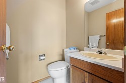 Wood-finish vanity with an integrated sink, polished chrome faucet, and full-width wall mirror - 