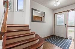 Entryway featuring a white door with decorative glass, a sidelight, and wood-finish flooring - 