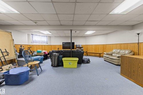 Carpeted flooring with wood-paneled wainscoting and a drop ceiling - 11139 157 Avenue Nw, Edmonton, AB - Indoor Photo Showing Basement
