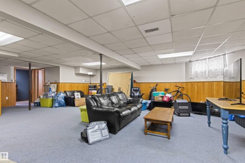 Carpeted lower level featuring a drop ceiling with recessed lighting, wood paneling, and a window - 11139 157 Avenue Nw, Edmonton, AB - Indoor Photo Showing Basement