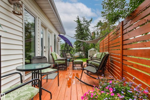 Expansive wood deck with a privacy fence, multiple outdoor seating areas, and a built-in garden bed - 11139 157 Avenue Nw, Edmonton, AB - Outdoor With Deck Patio Veranda With Exterior