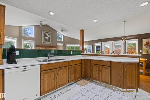 Kitchen featuring wood-finish cabinetry, white countertops, a tiled backsplash, and recessed lighting - 11139 157 Avenue Nw, Edmonton, AB - Indoor Photo Showing Kitchen With Double Sink