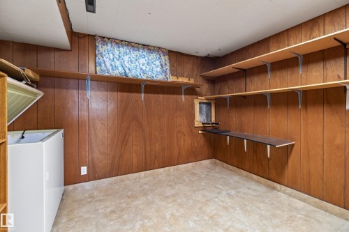Wood-paneled walls featuring multiple built-in shelving units and a single window - 8411 136 Avenue Nw, Edmonton, AB - Indoor
