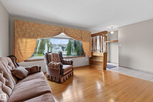 Hardwood flooring, broad window, built-in shelving, decorative room divider, overhead light fixture - 8411 136 Avenue Nw, Edmonton, AB - Indoor Photo Showing Living Room