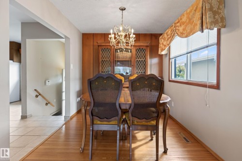 Hardwood flooring and a crystal chandelier illuminate this dining space - 8411 136 Avenue Nw, Edmonton, AB - Indoor Photo Showing Dining Room