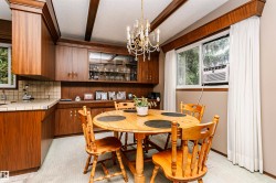 Dining area featuring wood-finish cabinetry, a built-in display hutch, tiled countertops, and a decorative chandelier - 
