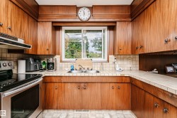 Kitchen featuring wood-finish cabinetry, a double basin sink, and a tiled countertop - 
