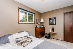 Neutral-toned walls complement the white window trim and dark wood door - 