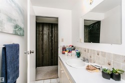 Bathroom featuring a white vanity with an integrated sink, chrome faucet, and tiled backsplash - 