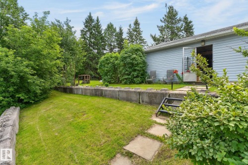 Expansive green space with concrete retaining walls and mature perimeter trees - 351 Smith Crescent, Rural Parkland County, AB - Outdoor
