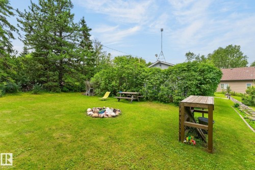 Expansive green lawn with a rock-lined fire pit - 351 Smith Crescent, Rural Parkland County, AB - Outdoor
