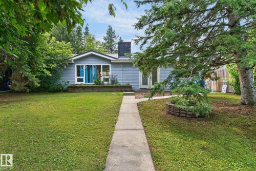 Light blue exterior siding, white trim, prominent front window, mature trees, and a concrete pathway leading to the entrance - 351 Smith Crescent, Rural Parkland County, AB - Outdoor