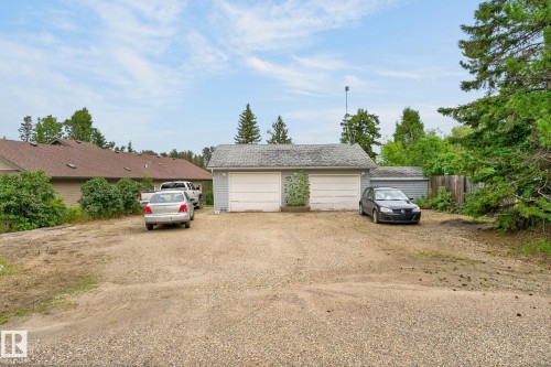 Detached garage with two white garage doors and a gravel driveway - 351 Smith Crescent, Rural Parkland County, AB - Outdoor