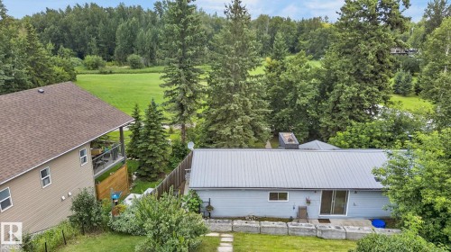 Light-colored siding home with a metal roof and sliding glass door - 351 Smith Crescent, Rural Parkland County, AB - Outdoor