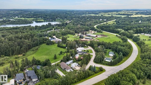 Expansive aerial perspective showcasing a lake, surrounding woodlands, and residential properties - 351 Smith Crescent, Rural Parkland County, AB - Outdoor With View