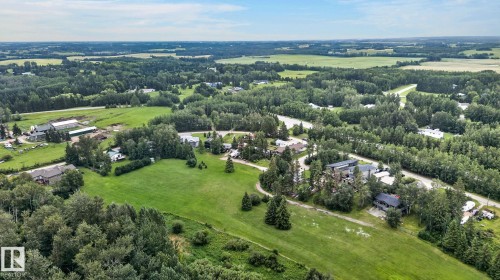 Expansive green landscape with numerous mature trees, a meandering river, scattered residential structures, and agricultural fields in the distance - 351 Smith Crescent, Rural Parkland County, AB - Outdoor With View