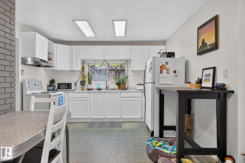Kitchen featuring white cabinetry, a dual-basin sink, and overhead illumination - 351 Smith Crescent, Rural Parkland County, AB - Indoor Photo Showing Kitchen
