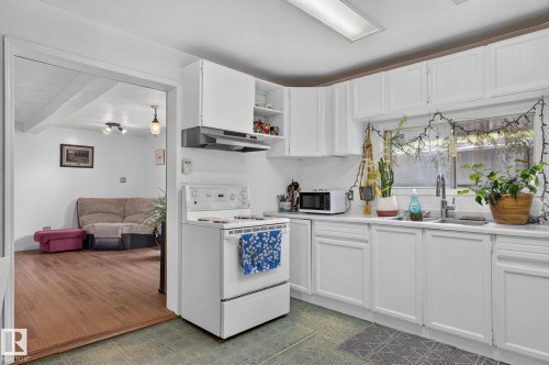White cabinetry, a stainless steel sink, and a four-burner electric range - 351 Smith Crescent, Rural Parkland County, AB - Indoor