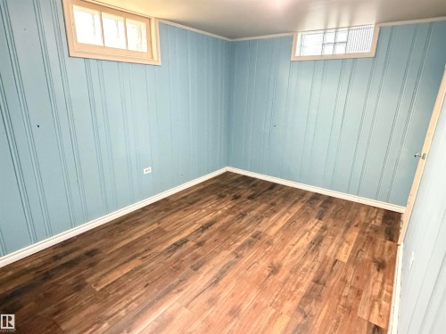 Wood-finish flooring, beadboard wall paneling, and a transom window - 10416 100 Avenue, Westlock, AB - Indoor Photo Showing Other Room