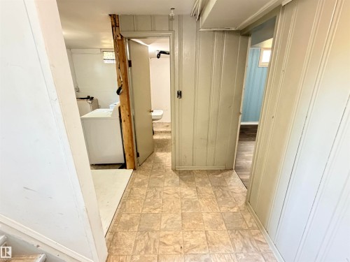 Tile-pattern flooring, beadboard wall paneling, and an interior door - 10416 100 Avenue, Westlock, AB - Indoor