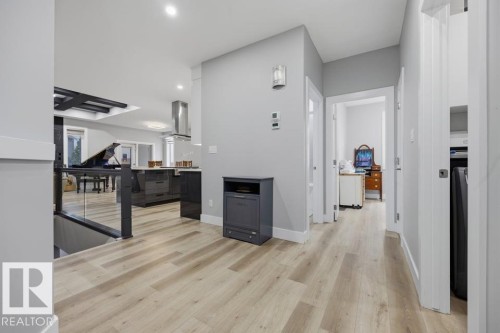 Wood-finish flooring throughout, recessed lighting, and a glass-paneled railing - 3303 Soleil Boulevard, Beaumont, AB - Indoor Photo Showing Other Room